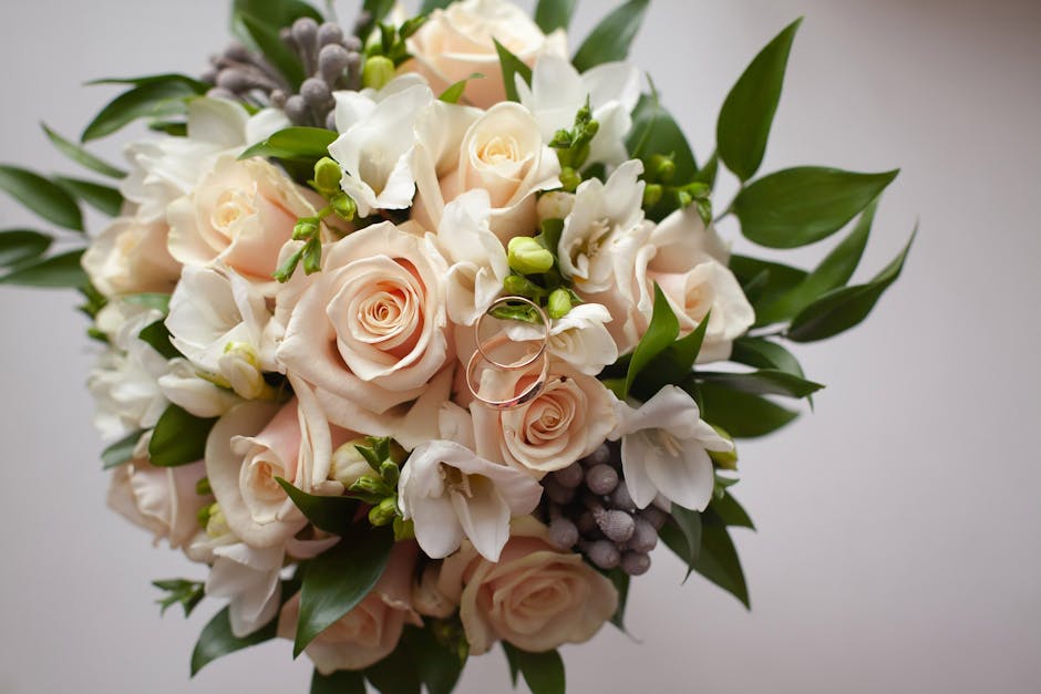 A close-up of a floral bouquet arranged by Dollis Hill florist, featuring pale blush pink roses with soft, layered petals, complemented by white freesias with delicate, trumpet-shaped blooms and small